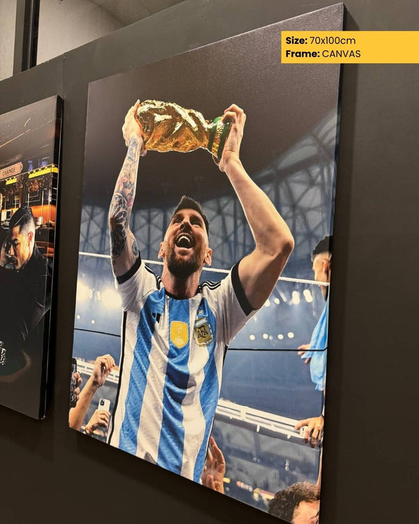 Framed canvas print of a soccer player holding a trophy against a dark background