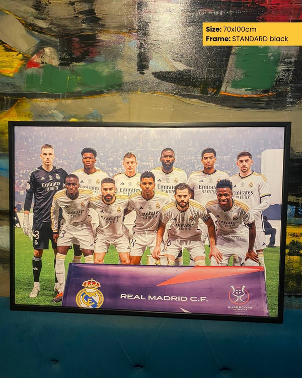 Framed poster of Real Madrid CF with players on a field, displayed against a reflective surface.