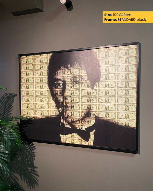 Framed artwork of a face with dollar bill pattern on a gray wall.