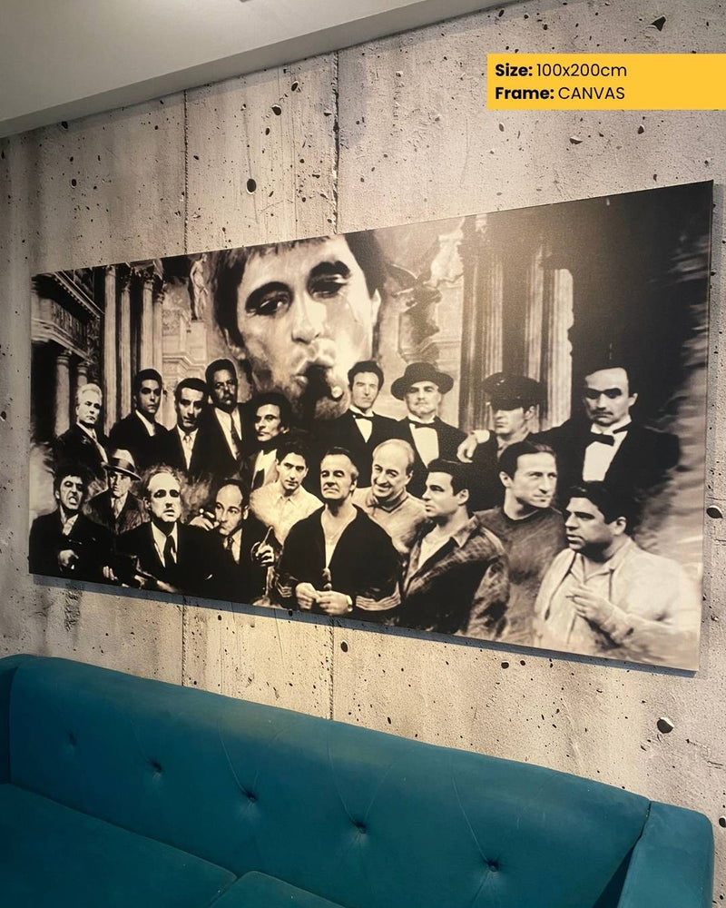 Large black and white portrait of a group of people on a textured wall with a blue sofa in the foreground.
