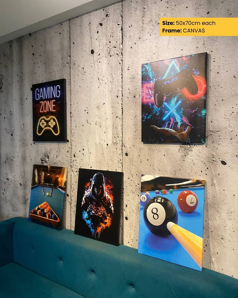 Canvas prints of gaming-themed designs on a concrete wall with a blue couch.