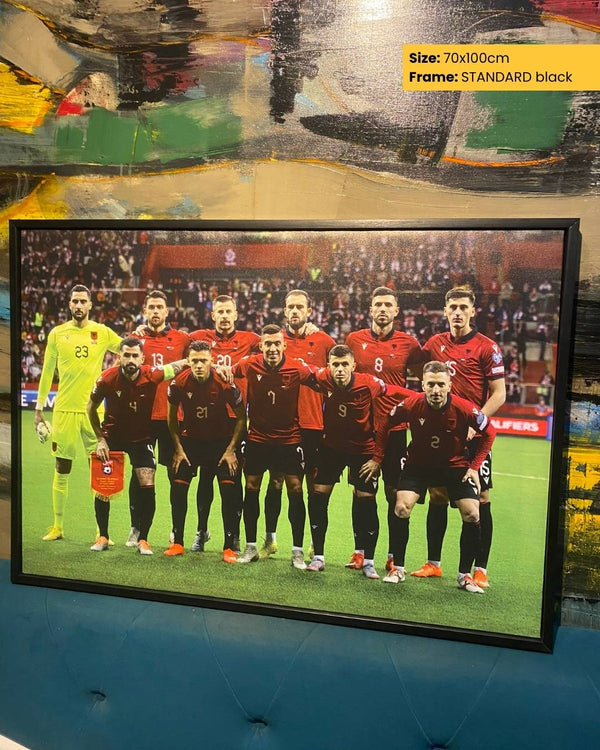 Framed photograph of a soccer team on a wall with a colorful abstract painting.