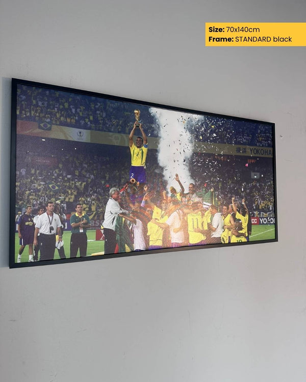 Framed picture of a sports event with people celebrating on a wall.