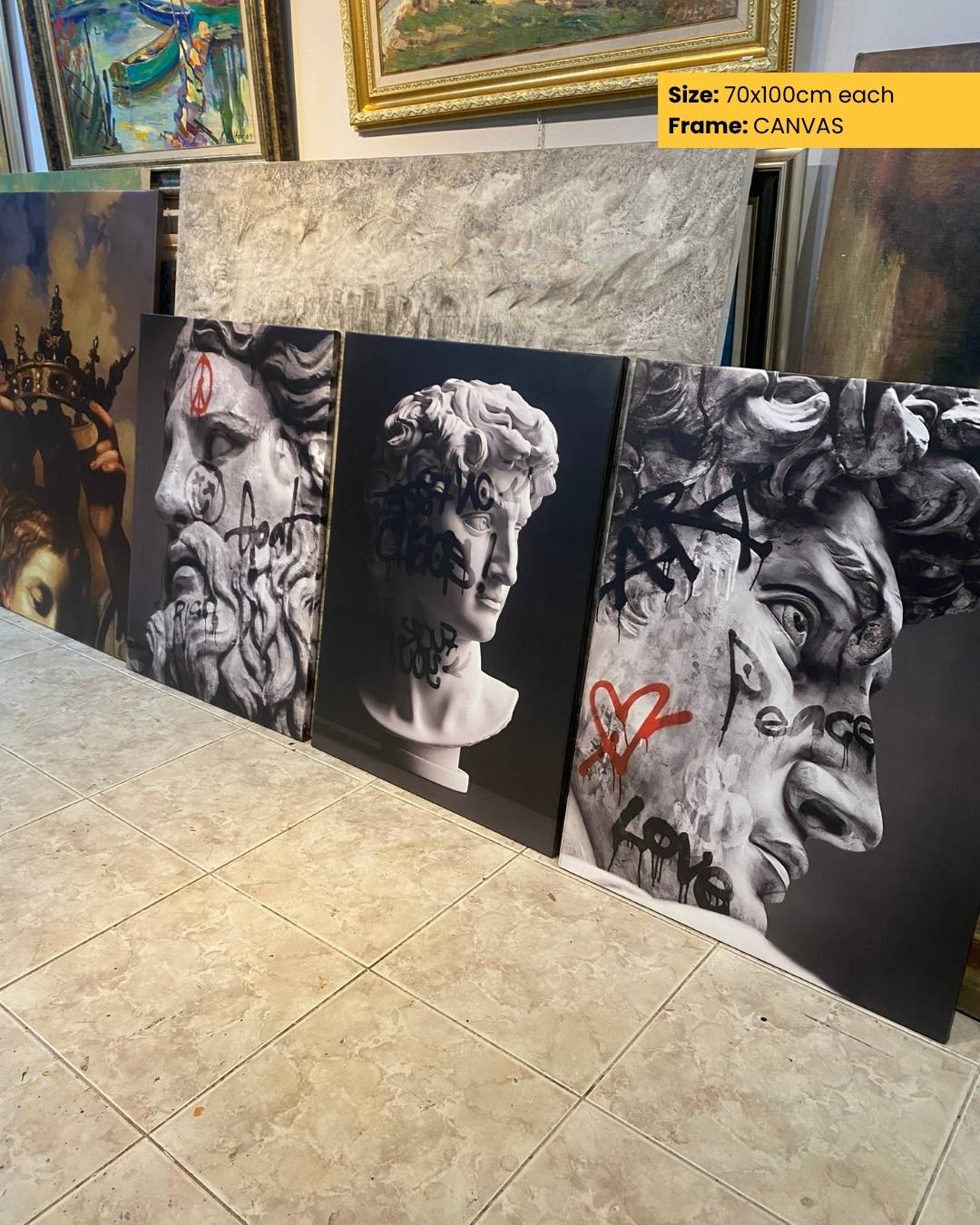 Three artistic canvases with abstract designs displayed on a tiled floor.