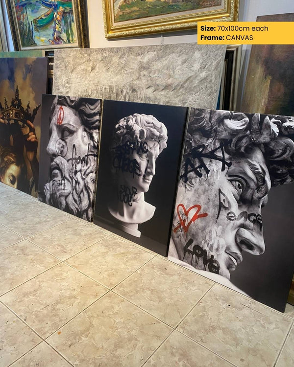 Three artistic canvases with abstract designs displayed on a tiled floor.
