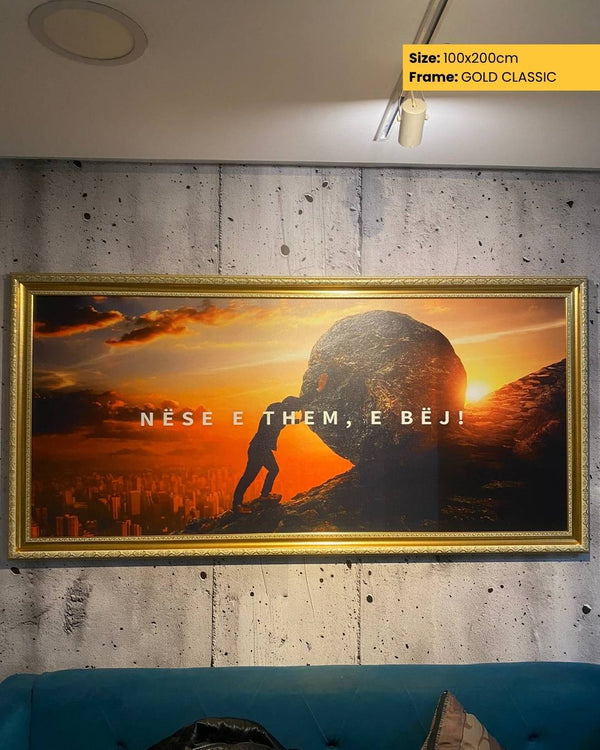 Framed artwork with a sunset scene and text on a concrete wall.