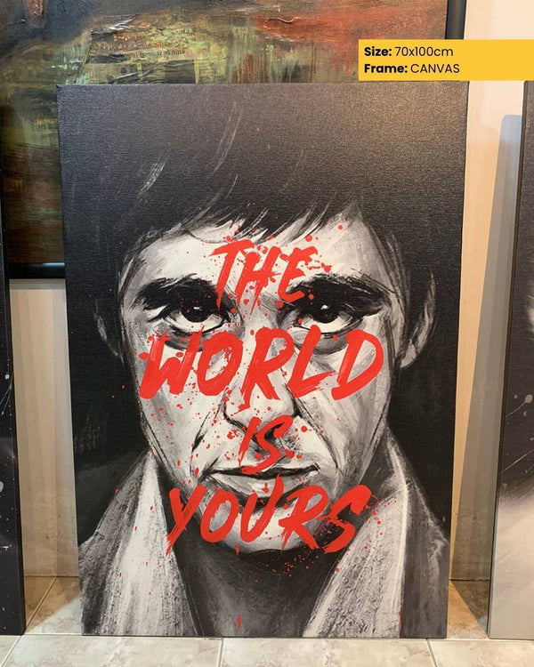 Canvas print of a stylized portrait with 'The World is Yours' text, displayed indoors.