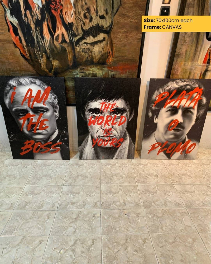 Three canvas prints with bold text and artistic designs on a tiled floor.