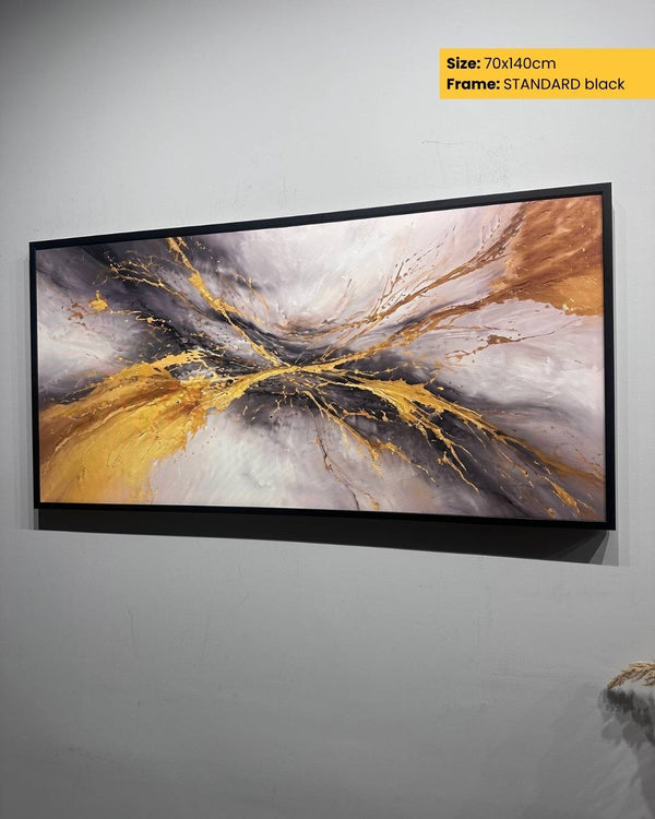 Abstract art print with gold and gray colors in a black frame on a white wall.