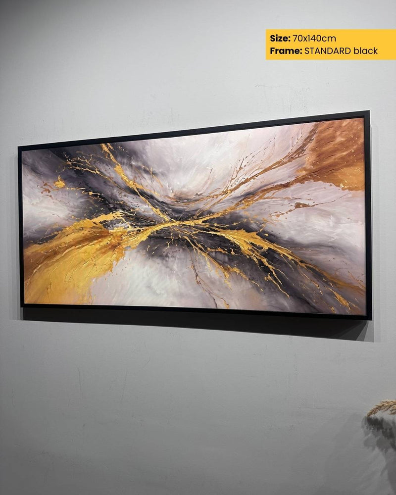 Abstract art print with gold and gray colors in a black frame on a white wall.