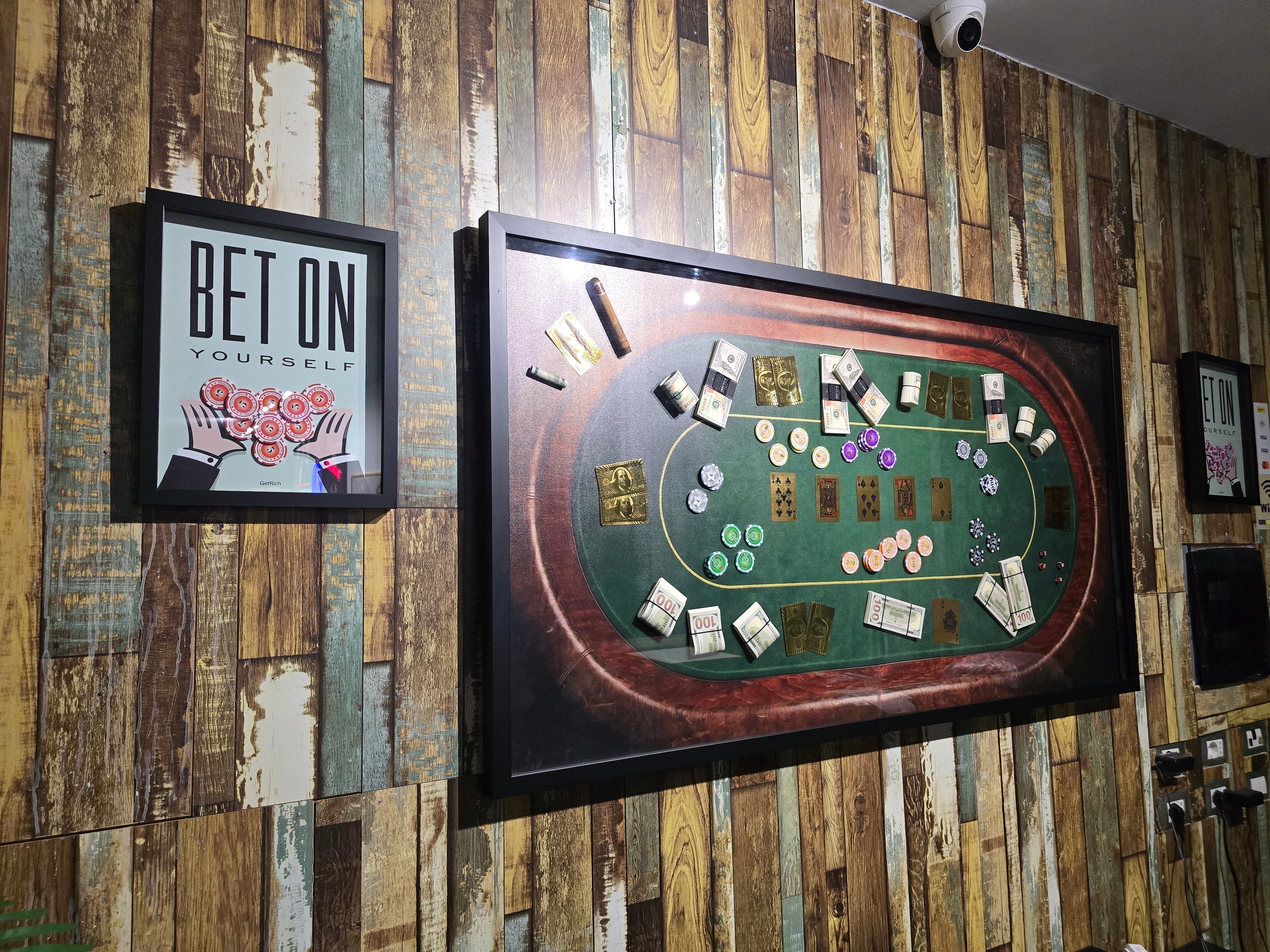 Framed blackjack table setup on a wooden wall with 'BET ON YOURSELF' sign.