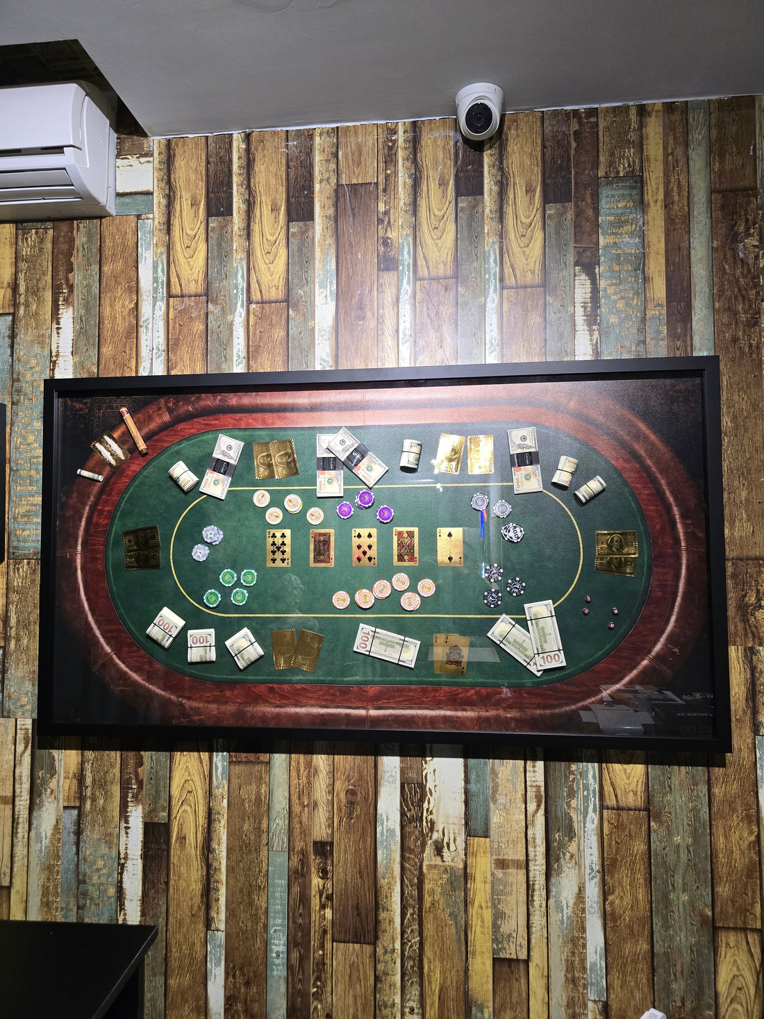 Decorative wall art resembling a card game layout on a wooden paneled wall.