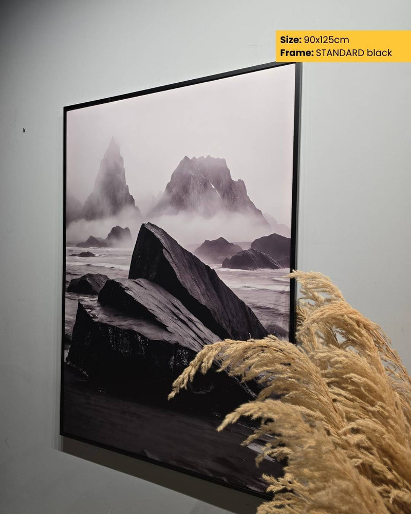 Framed artwork of a mountain landscape on a wall with decorative pampas grass.