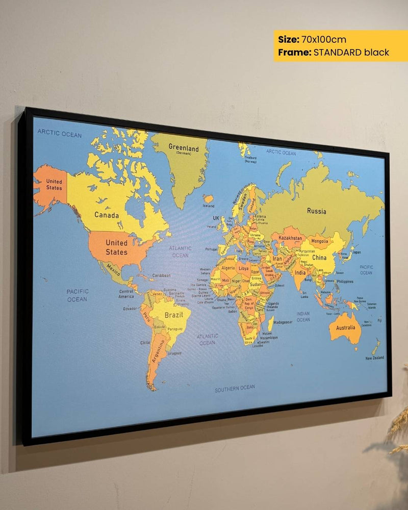 World map poster with a black frame on a wall
