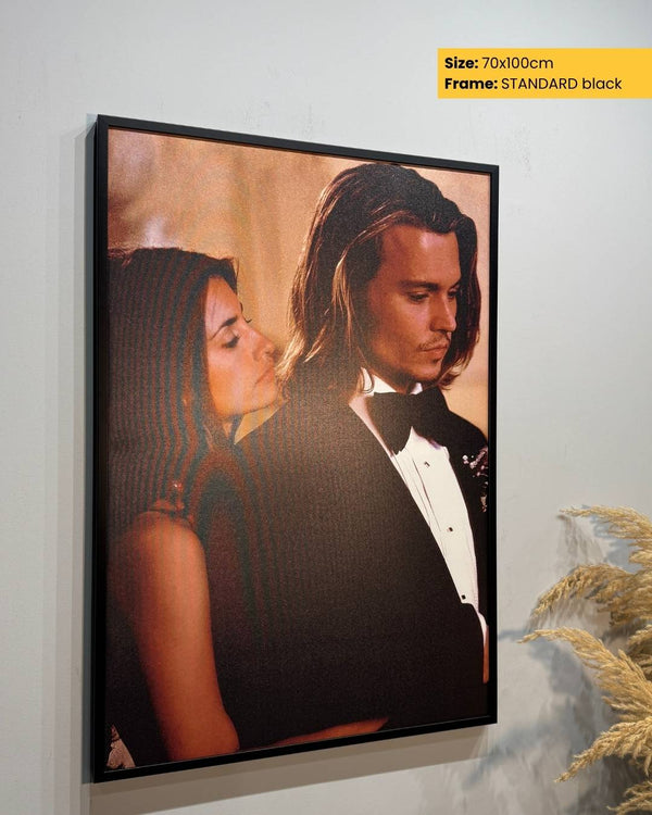 Framed artwork of a couple on a wall with decorative elements.