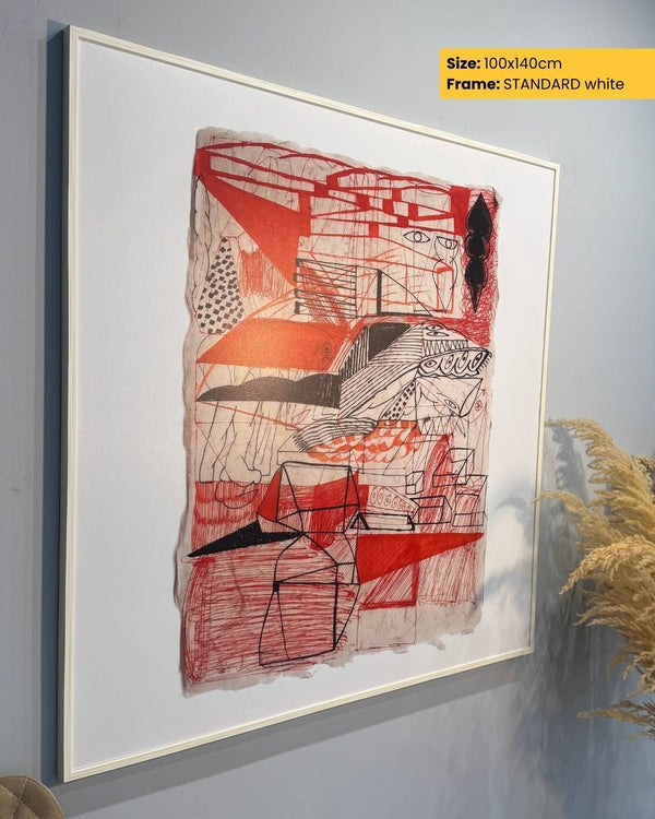 Abstract artwork with red, black, and white colors in a white frame on a gray wall.
