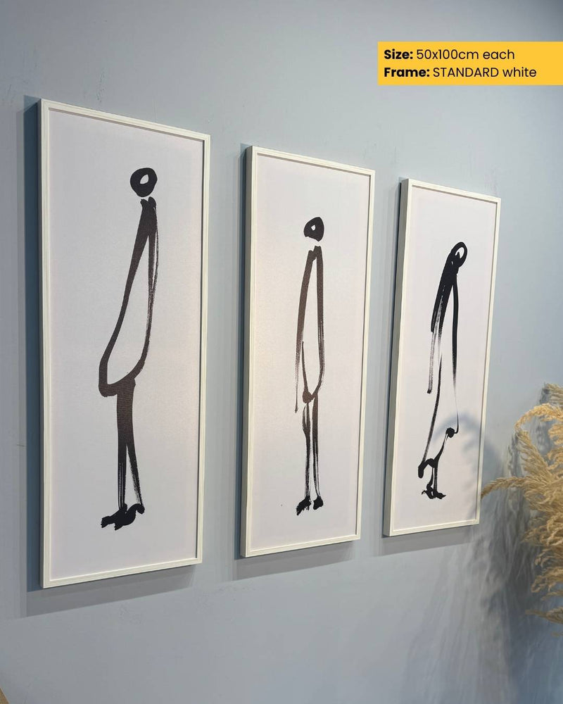 Three framed black and white abstract art pieces on a gray wall.