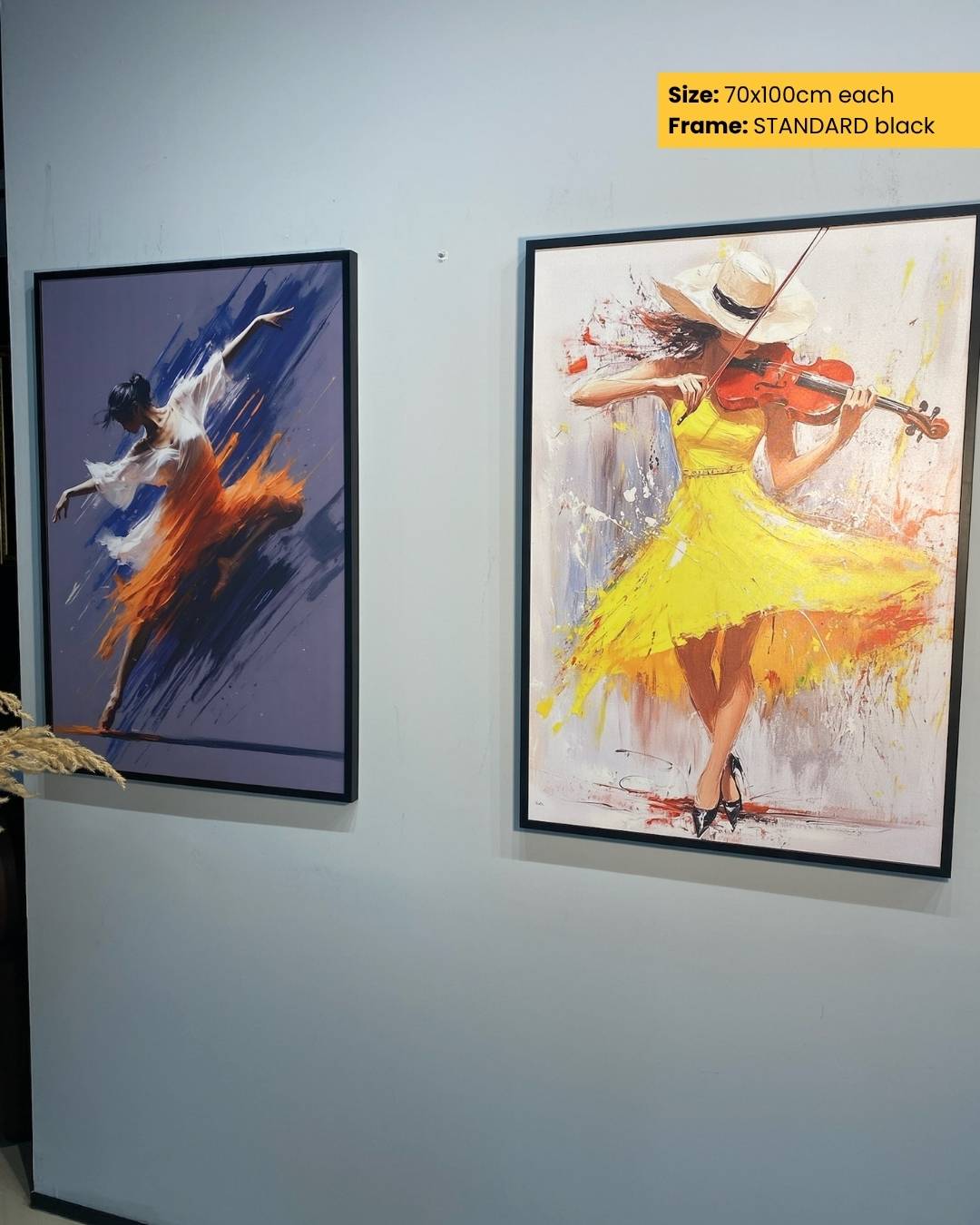 Two framed artworks on a wall, one with a dancer in a yellow dress and another with a figure in a blue outfit.