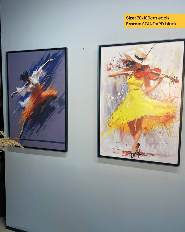 Two framed artworks on a wall, one with a dancer in a yellow dress and another with a figure in a blue outfit.