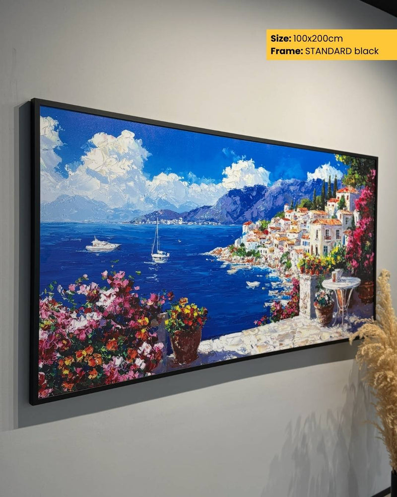 Framed artwork of a coastal scene with houses, boats, and flowers on a gray wall.