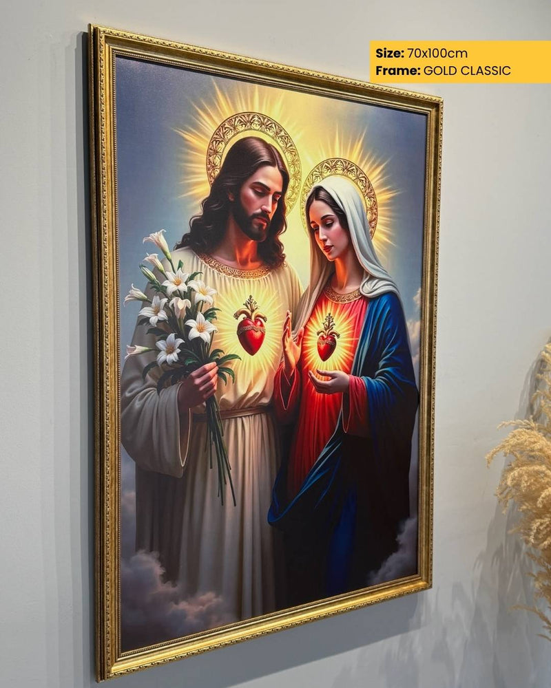 Framed artwork of a religious scene with two figures holding flowers and hearts, on a light gray wall.