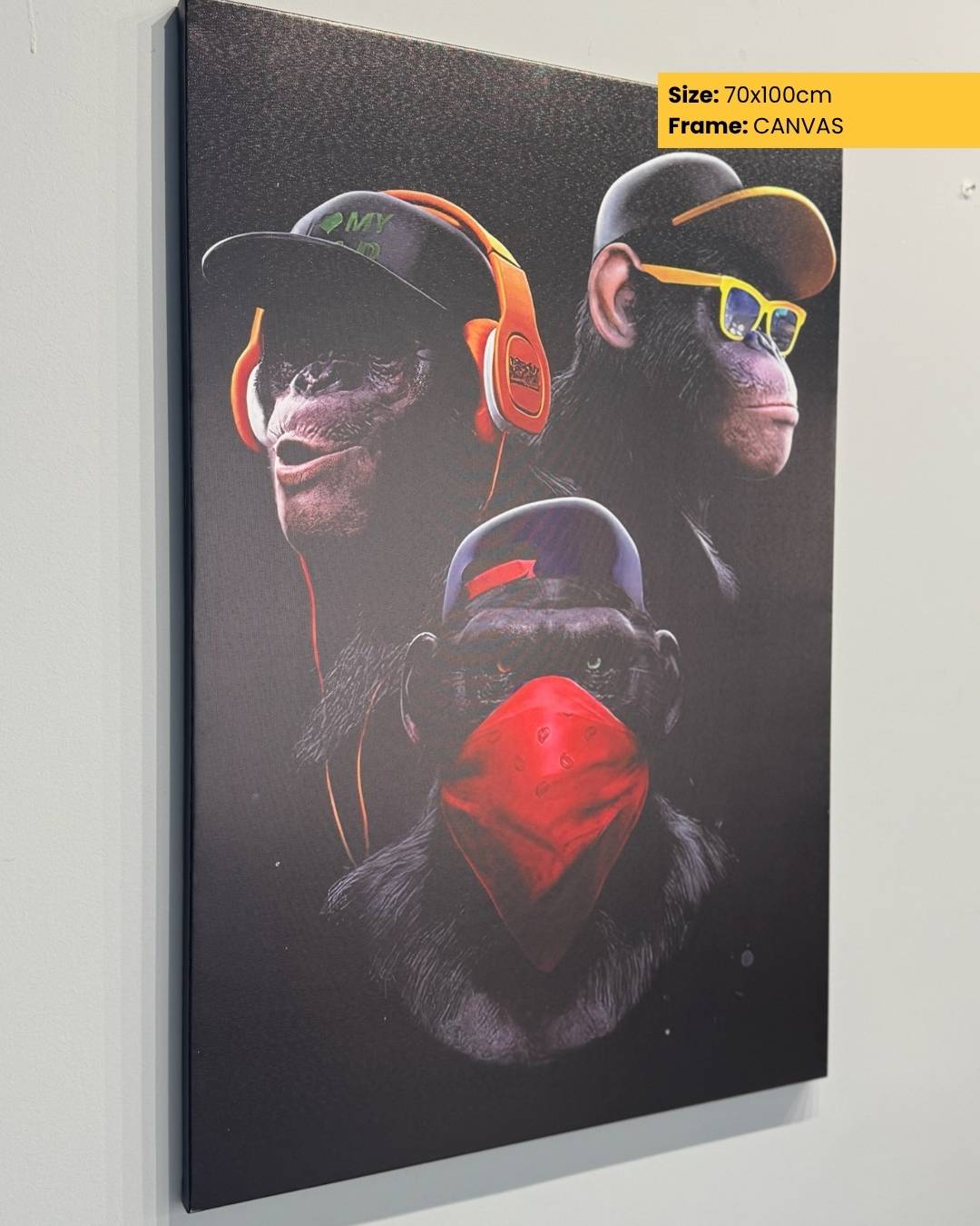 Canvas print of three chimpanzees wearing headphones and a mask, framed by a yellow border with text.
