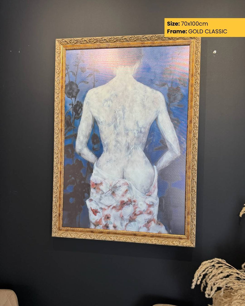 Framed artwork of a nude figure with a gold frame on a dark wall.