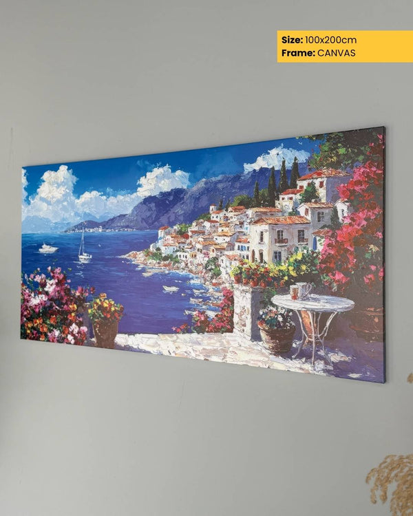 Canvas print of a coastal scene with houses, flowers, and mountains on a gray wall.