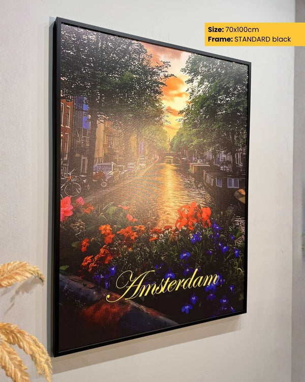 Framed artwork of a canal scene with flowers and 'Amsterdam' text on a wall.