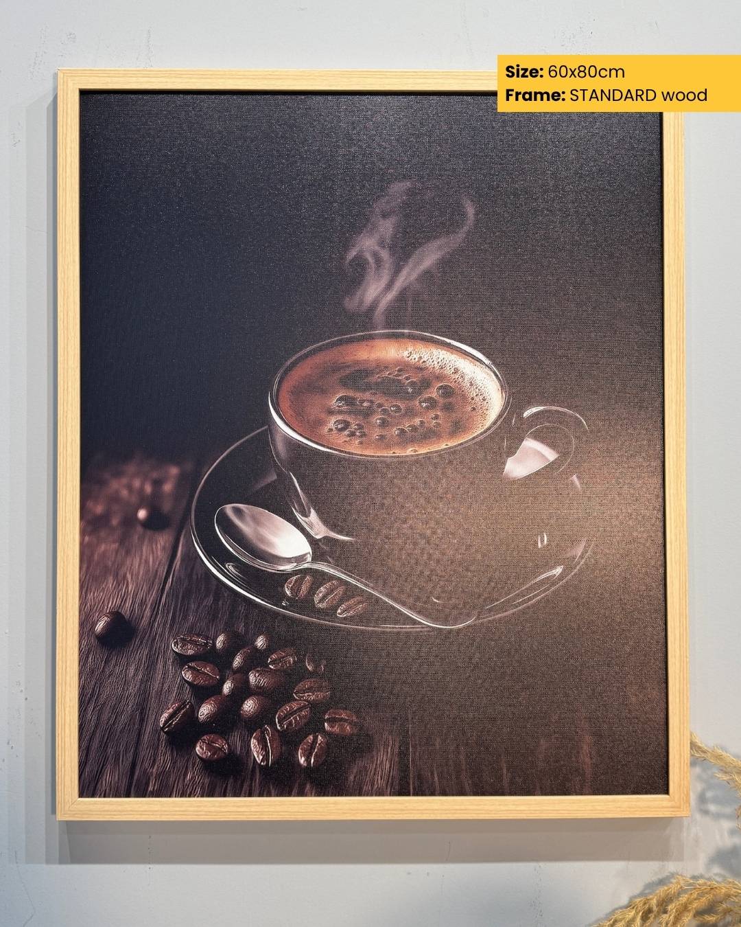 Framed artwork of a steaming coffee cup and beans on a wooden surface.