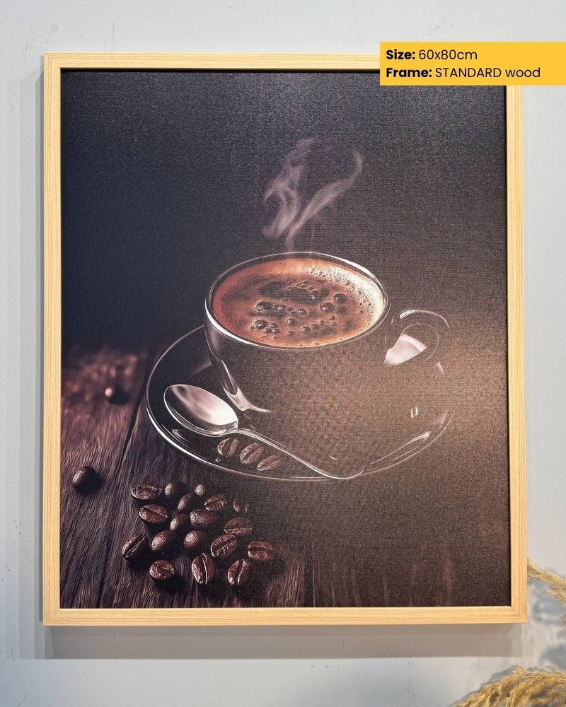 Framed artwork of a steaming coffee cup and beans on a wooden surface.