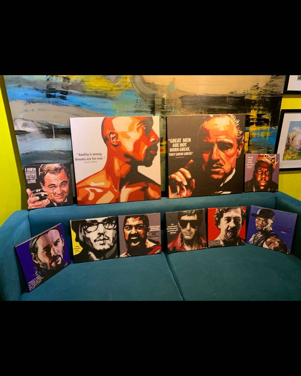 Collection of framed pictures on a blue couch with a colorful wall background.
