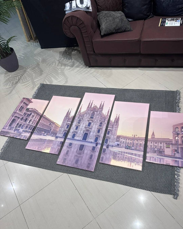 Four prints of a architectural scene on a rug in a living room.