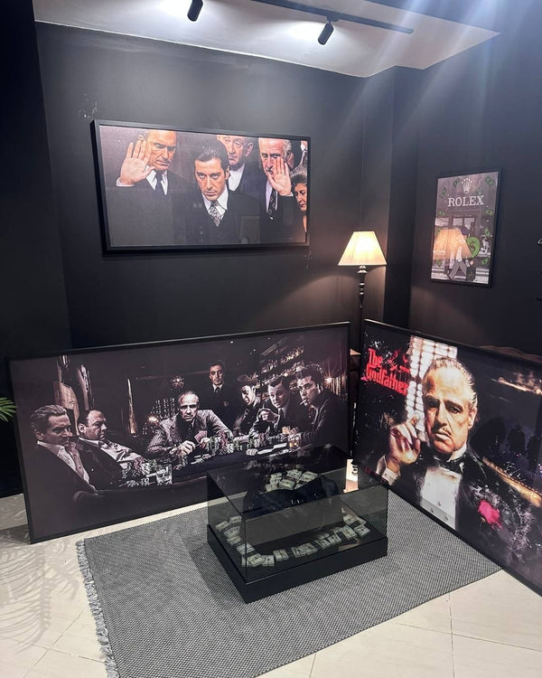 Display of framed movie posters and a TV screen showing a scene from a film in a room with dark walls.