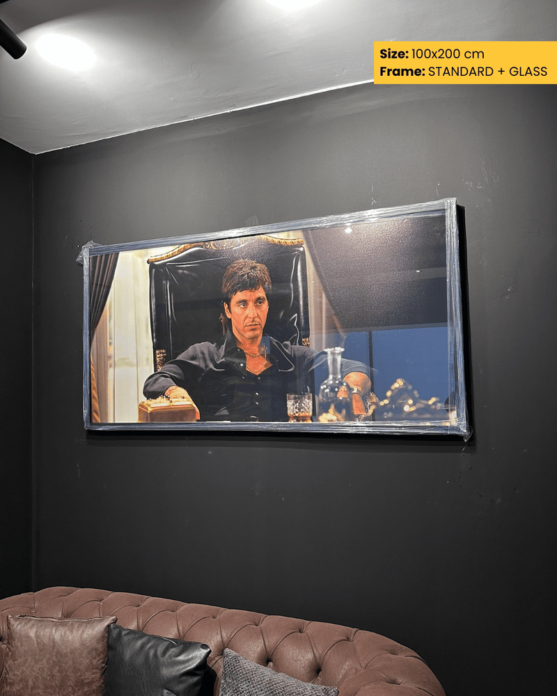 Large framed picture of a man in a room with a sofa in the foreground