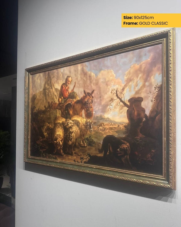 Framed painting of a pastoral scene with gold frame on a white wall