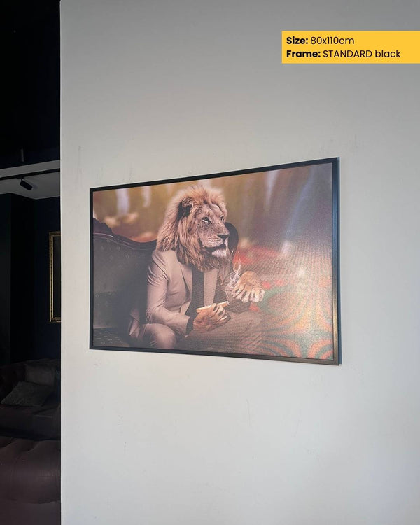 Framed artwork of a lion wearing a suit on a white wall.