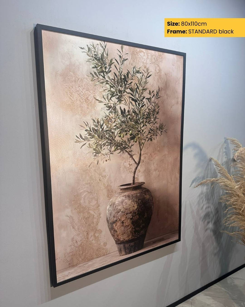 Framed artwork of a vase with a plant on a textured wall.