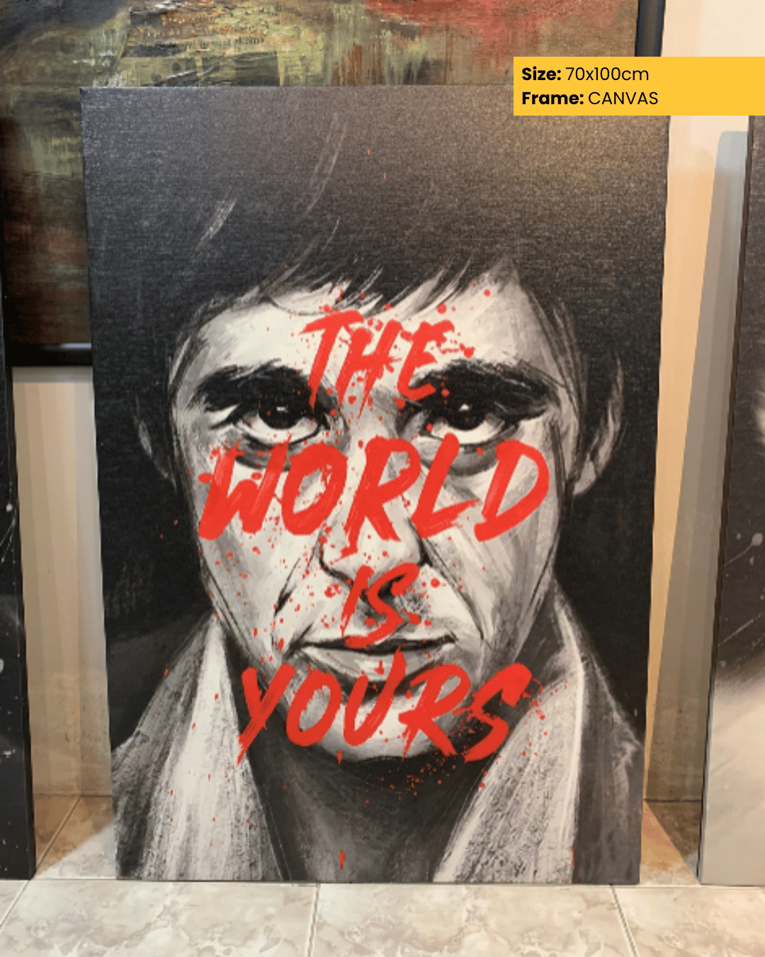 Canvas print with a stylized portrait and 'The World is Yours' text, displayed indoors.