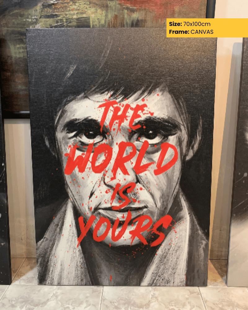 Canvas print with a stylized portrait and 'The World is Yours' text, displayed indoors.
