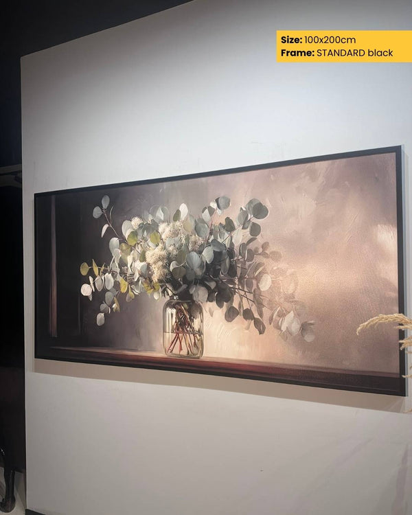 Large framed artwork of a vase with flowers on a white wall.
