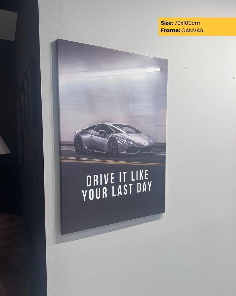 Framed poster with a car and motivational quote on a white wall.