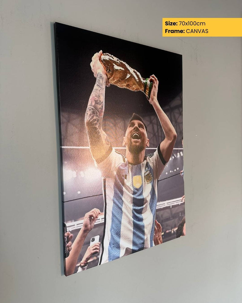 Canvas print of a soccer player holding a trophy against a gray wall.