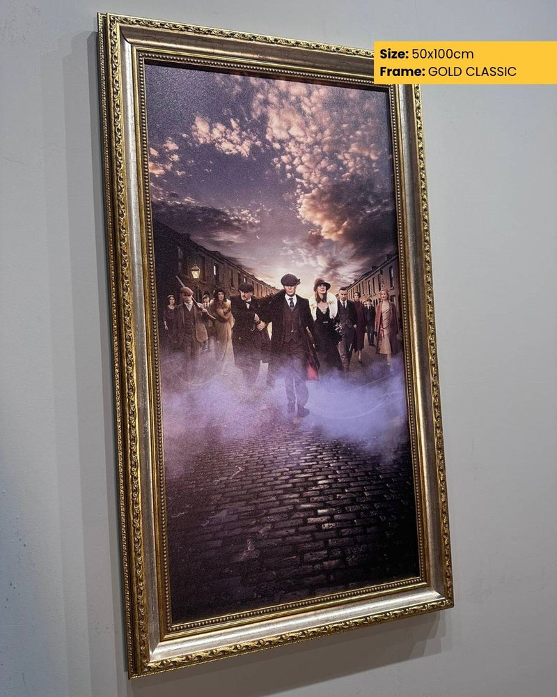 Framed artwork of a scene with people on a street, gold frame, size 50x100cm.