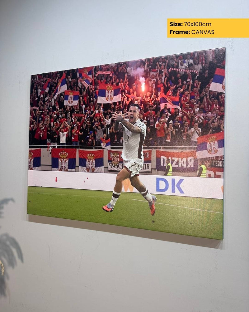 Canvas print of a soccer player celebrating with fans in the background, displayed on a wall.