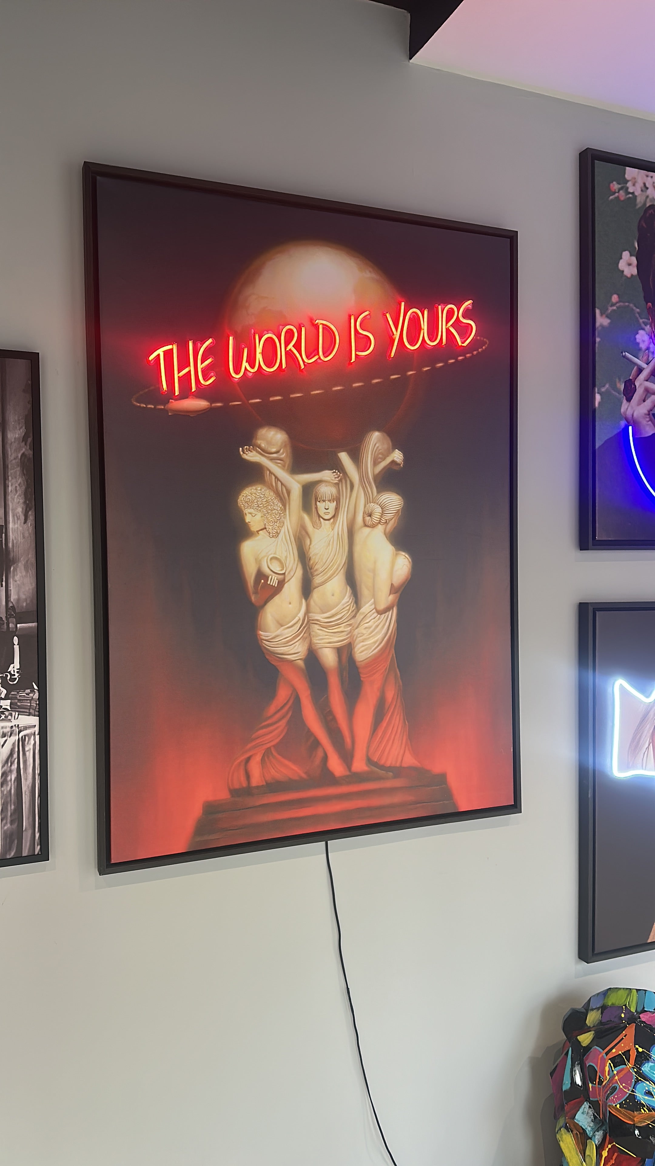 Framed poster with text 'The World is Yours' on a white surface.