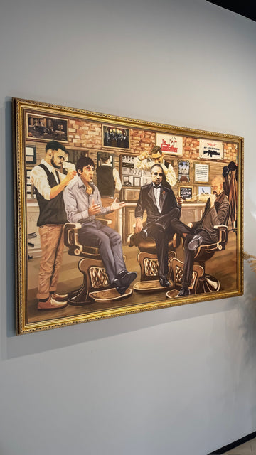 Framed artwork of a barbershop scene with multiple barbers and customers.