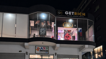 Commercial building with 'Getrich' and 'Art' signs at night.