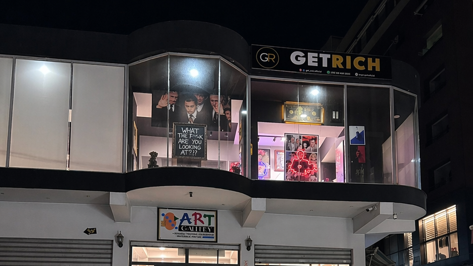 Commercial building with 'Getrich' and 'Art' signs at night.1621243260e1af0c20-0
