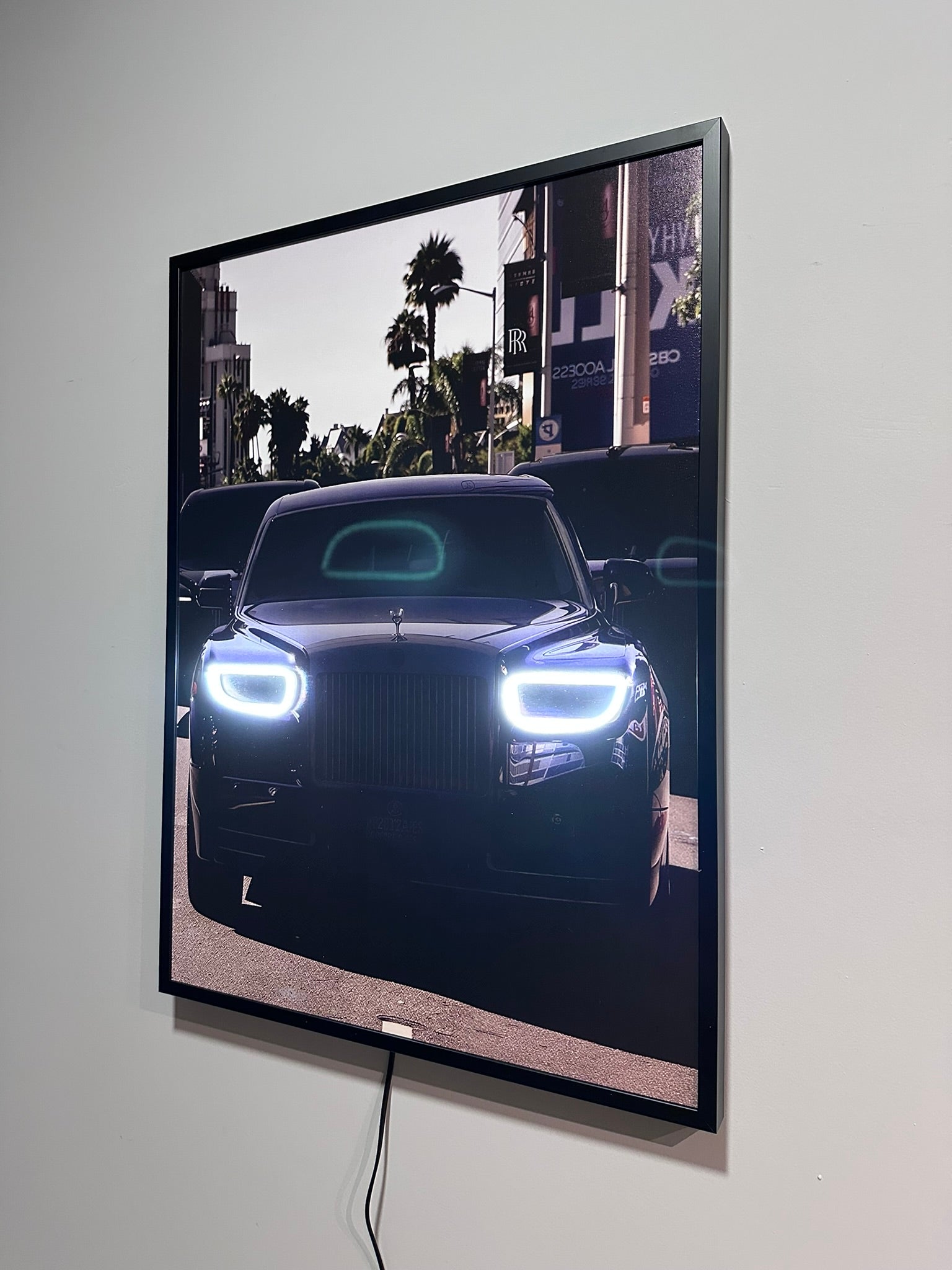 Large screen displaying a car on a city street with palm trees.